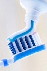 toothpaste being put on toothbrush