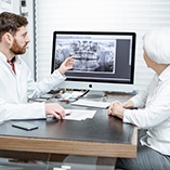 implant dentist in Park Slope showing a patient their dental X-rays 