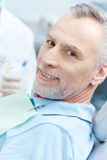 a patient smiling after paying the cost of dentures