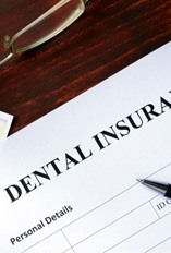 A dental insurance form set against a wooden desk