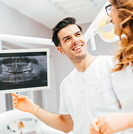 dentist looking at dental x-ray, smiling