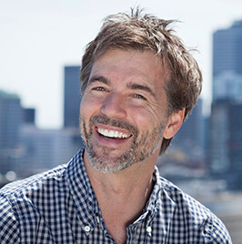 man sitting outside, smiling