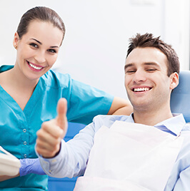 dental patient giving a thumbs up