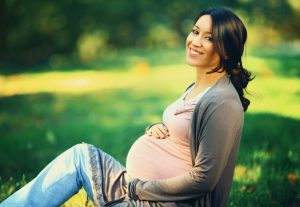 Pregnant woman with a beautiful smile achieved with help from her Park Slope dentist.