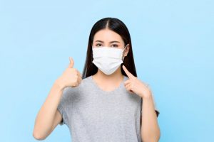 young woman wearing face mask to dental visit 