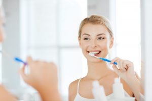 Woman looking in mirror to brush teeth